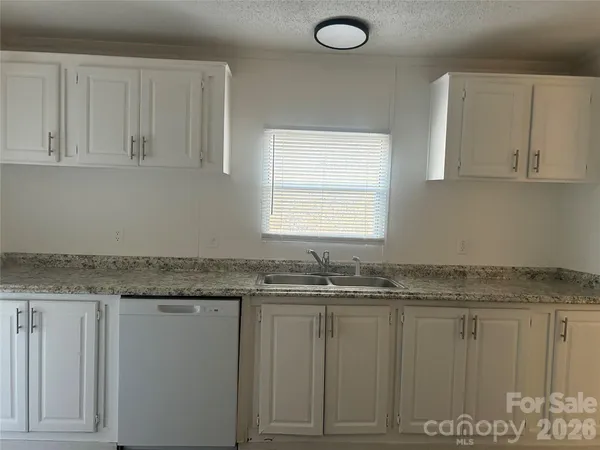 a kitchen with granite countertop a sink white cabinets and a granite counter tops