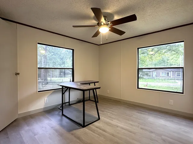 a view of a workspace with furniture and a window