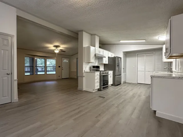 a view of kitchen with refrigerator and wooden floor