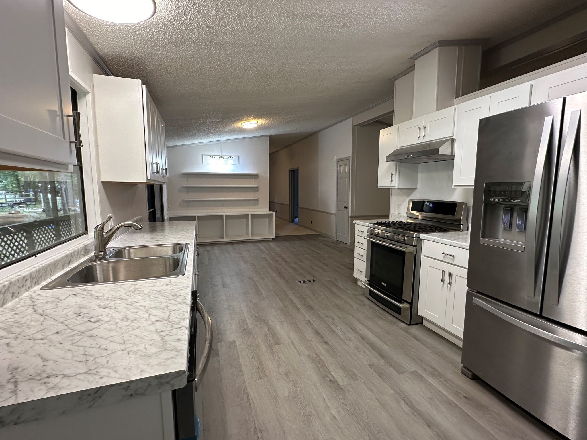 195 Charlies Lane Trinity, TX 75862 - Photo 22 of 25 a kitchen with stainless steel appliances wooden floor sink and wooden floor