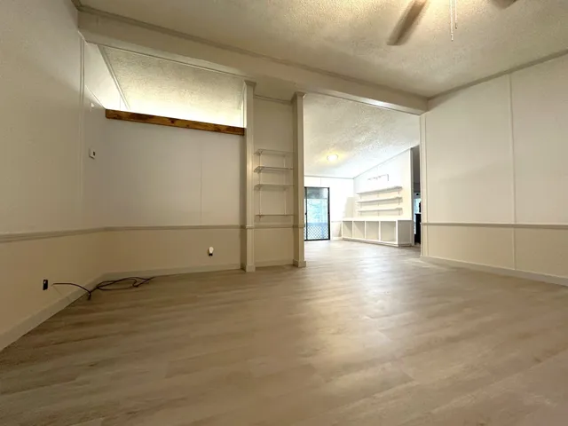a view of a livingroom with an empty space and a window