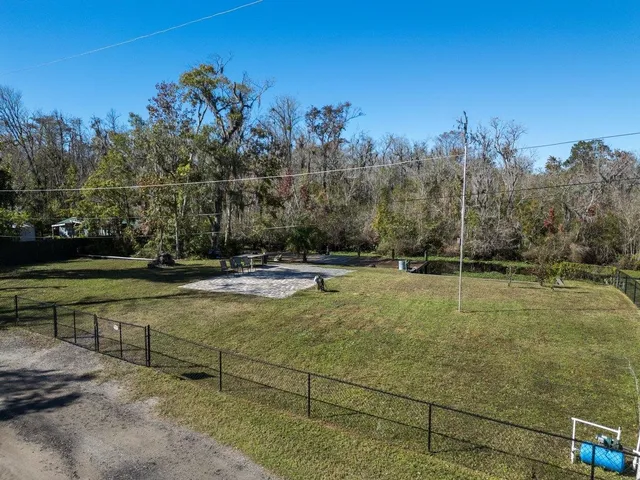 a view of a swimming pool with a yard and trees