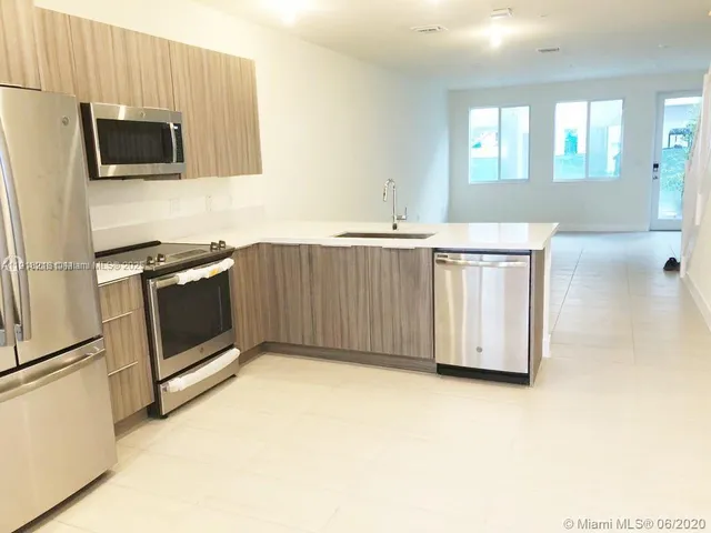 a kitchen with stainless steel appliances a stove microwave and sink