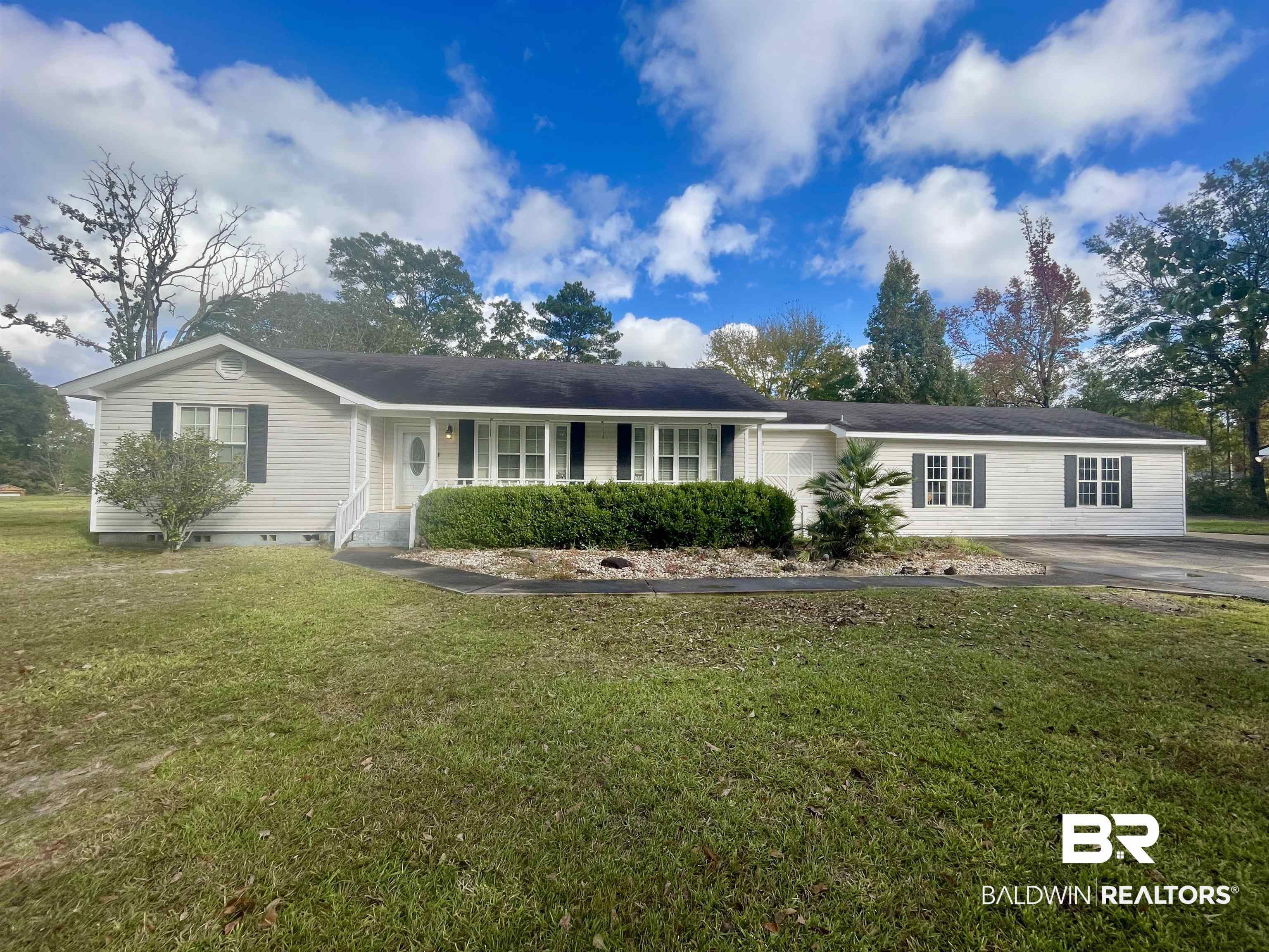 Single story home with a porch, crawl space, and a front yard