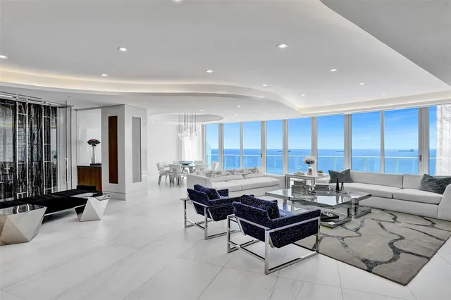 a living room with fireplace furniture and a view of kitchen