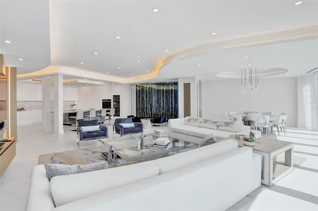 a view of a dining room with furniture a kitchen and chandelier