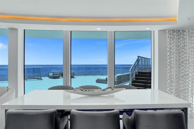 a view of a dining room with furniture large windows and wooden floor