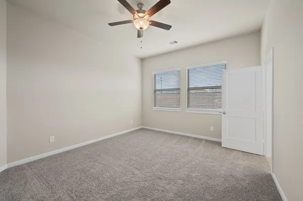 a view of a big room with chandelier fan and windows