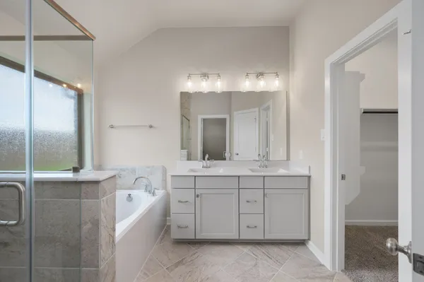 a bathroom with a granite countertop sink a mirror bathtub and shower