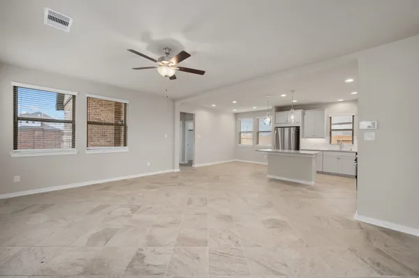 a view of an empty room with a window and fireplace