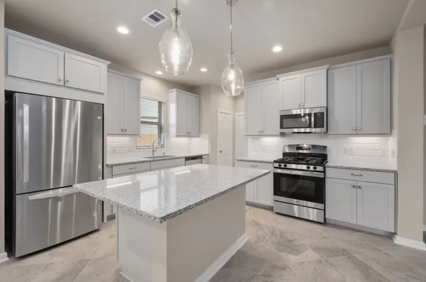 a kitchen with stainless steel appliances granite countertop a stove top oven a sink and a microwave