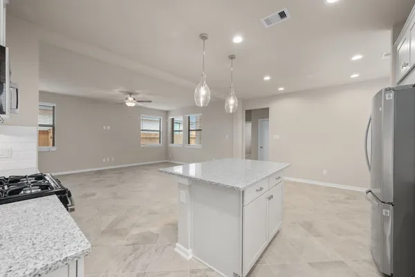 an empty room with windows and fan