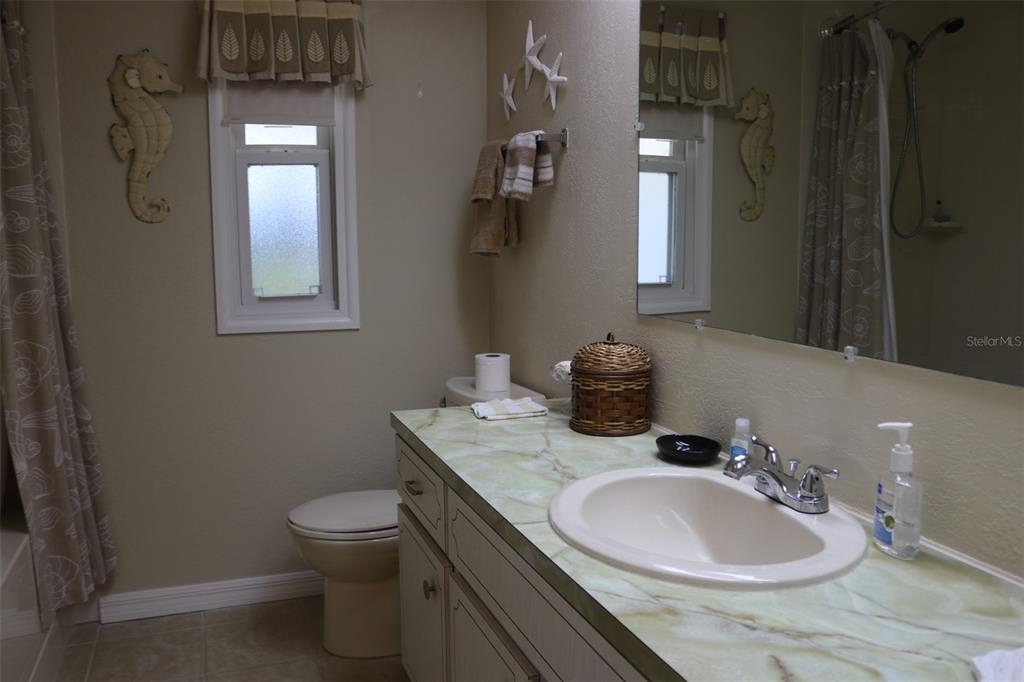 316 Estrada Street North Port, FL 34287 - Photo 24 of 59 a bathroom with a granite countertop sink a toilet and mirror