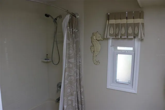 a bed sitting in a bedroom next to a window with lamp