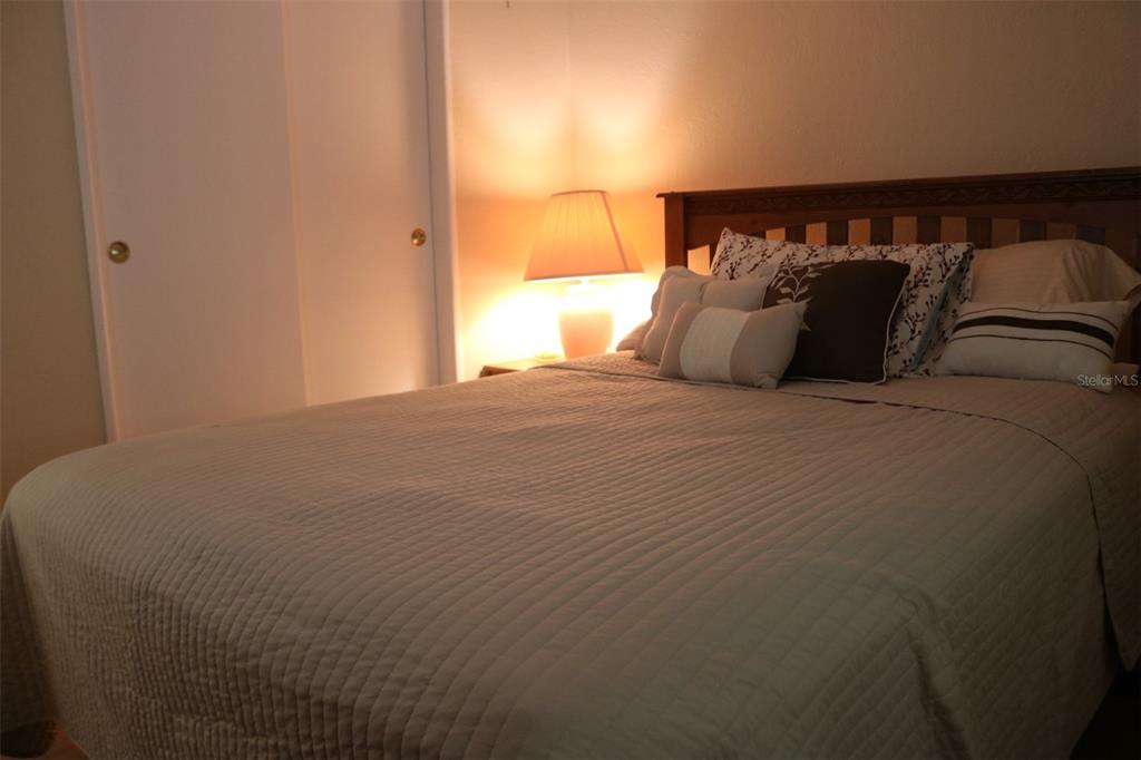 316 Estrada Street North Port, FL 34287 - Photo 28 of 59 a bed sitting in a bedroom next to a window with lamp