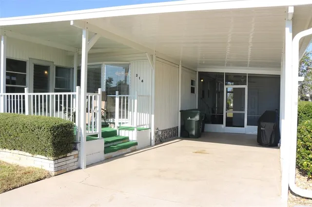 a view of a house with a yard and palm trees