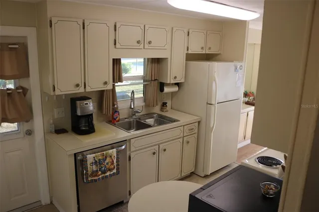 a kitchen with white cabinets and white appliances