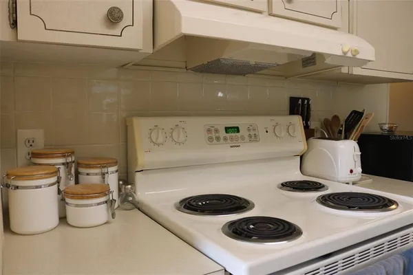 a kitchen with a stove and a white refrigerator