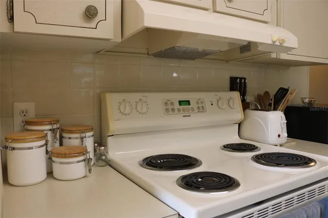 a kitchen with a stove and a white refrigerator