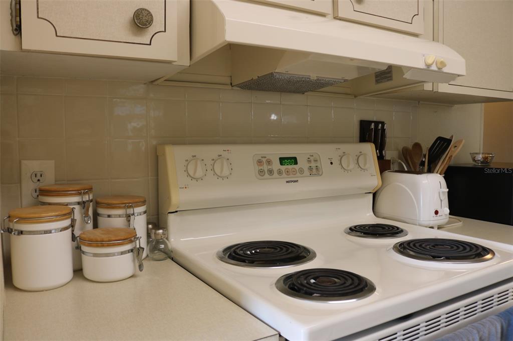 316 Estrada Street North Port, FL 34287 - Photo 5 of 59 a kitchen with a stove and a white refrigerator