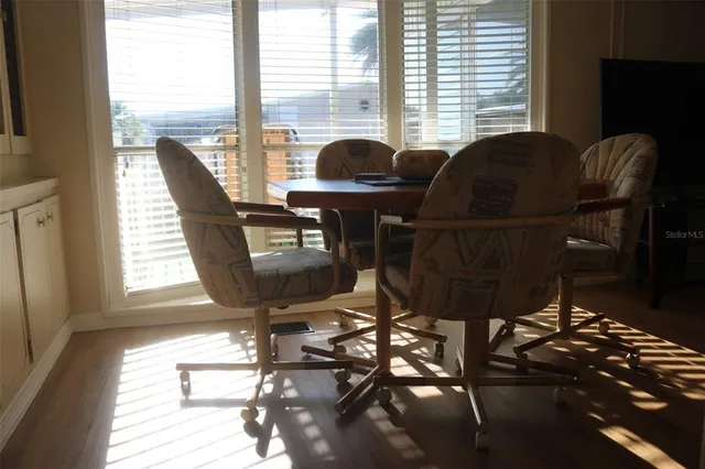 a dining room with furniture a chandelier and wooden floor