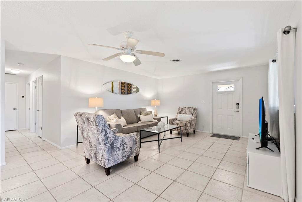 136 Harrison Road, Unit 1 Naples, FL 34112 - Photo 6 of 29 Spacious living area featuring light-toned tile flooring, recessed lighting, and a ceiling fan with integrated illumination