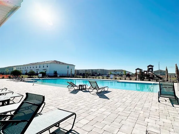 a view of swimming pool with outdoor seating and a potted plant