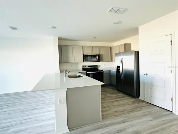 a kitchen with stainless steel appliances granite countertop a refrigerator a stove and a microwave