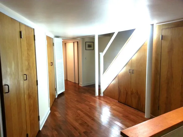 a view of hallway with wooden floor and stairs