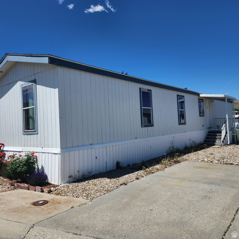 3760 Gold Ridge Drive, Unit 82 Magna, UT 84044 - Photo 4 of 29 White vertical siding exterior with contrasting dark trim