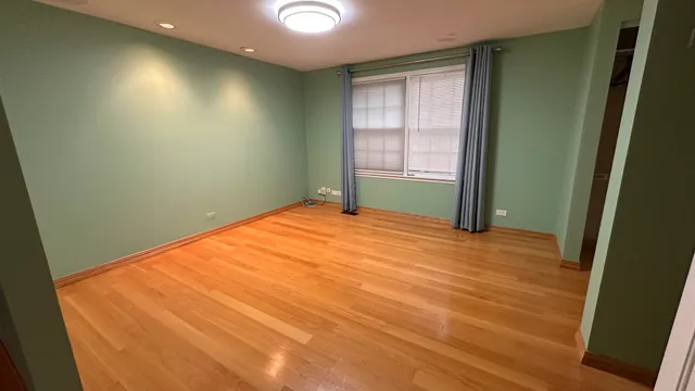 a room with a wooden floor and windows
