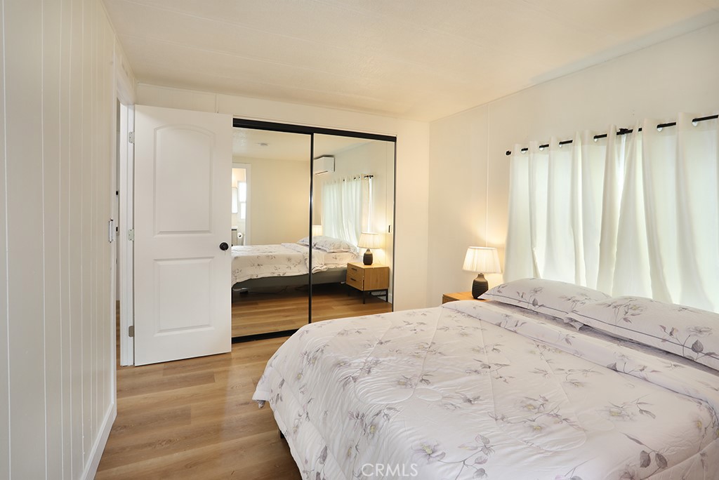 17261 Gothard Street, Unit 60 Huntington Beach, CA 92647 - Photo 17 of 27 a bedroom with a bed and a mirror