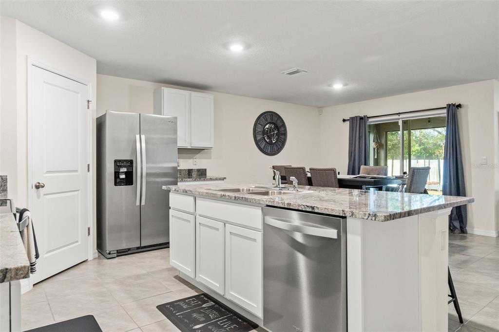 2448 Dothan Avenue Spring Hill, FL 34609 - Photo 5 of 20 a kitchen with stainless steel appliances granite countertop a sink and a refrigerator