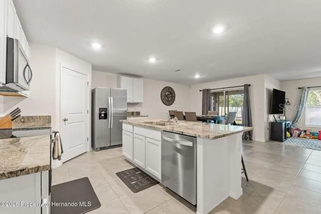 a kitchen with stainless steel appliances granite countertop a stove oven and white cabinets