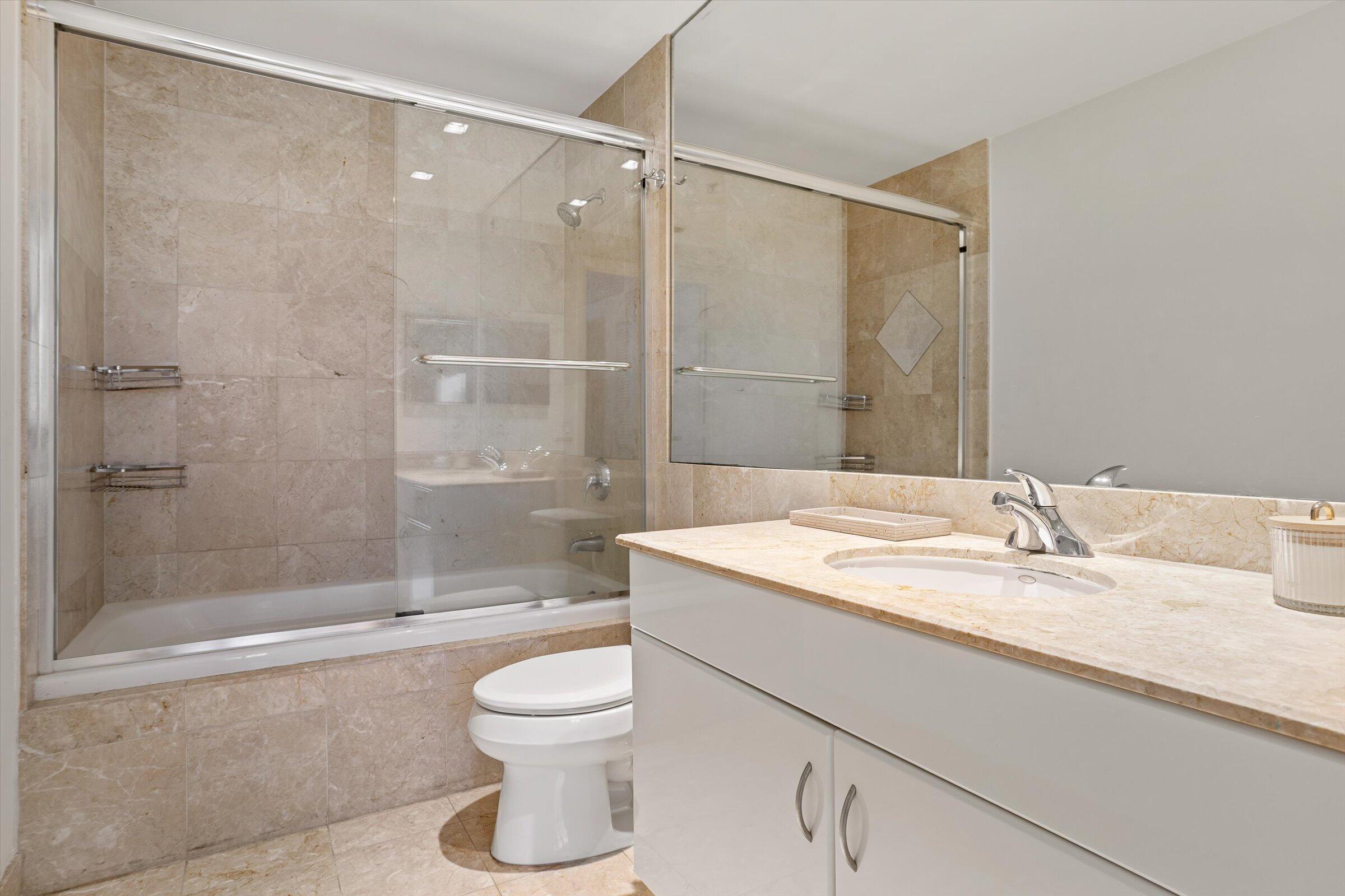 801 Brickell Key Boulevard, Unit 2805 Miami, FL 33131 - Photo 21 of 42 a bathroom with a granite countertop sink toilet and shower