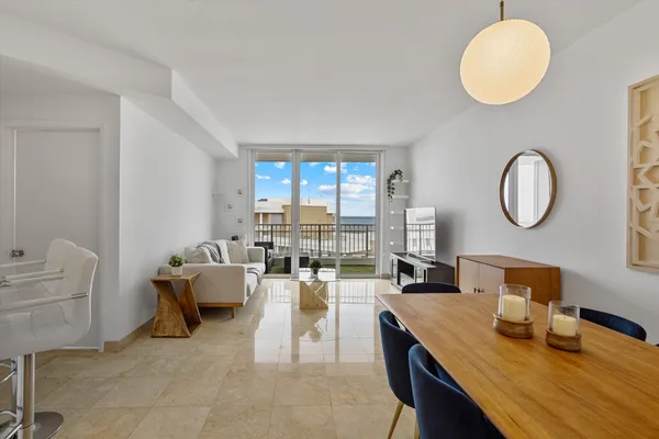 a living room with couches chairs and a large mirror with wooden floor