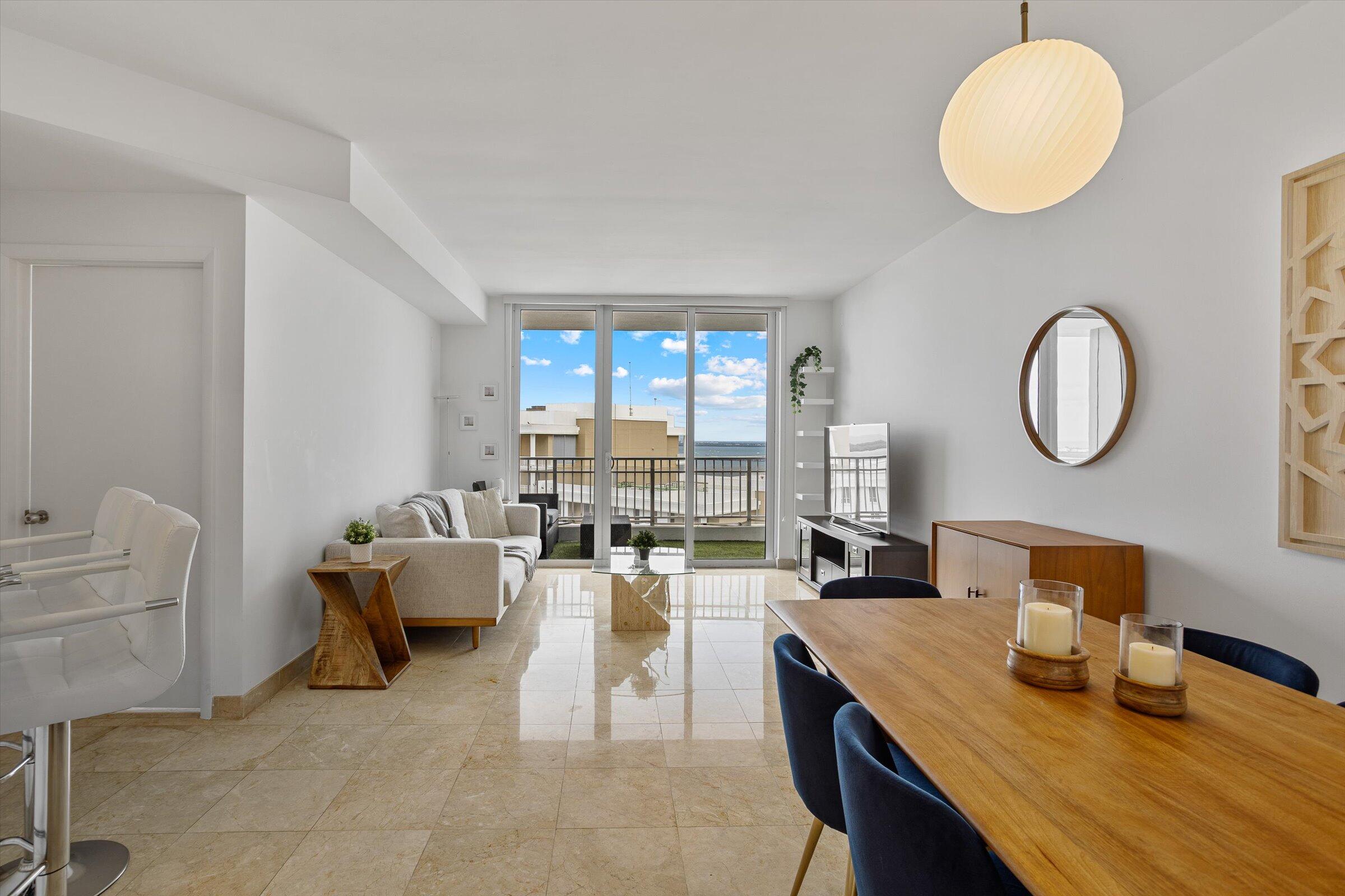 801 Brickell Key Boulevard, Unit 2805 Miami, FL 33131 - Photo 5 of 42 a living room with couches chairs and a large mirror with wooden floor