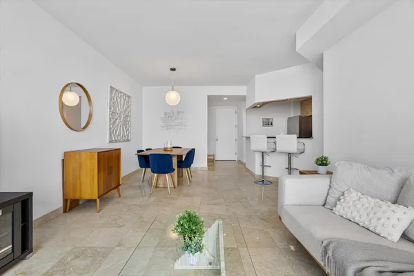 a living room with furniture and kitchen view