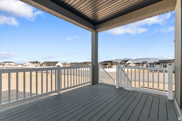 562 West Coyote Rdg Road Grantsville, UT 84029 - Photo 16 of 27 Covered deck with composite decking and white railing, featuring a clear sky and distant mountain backdrop