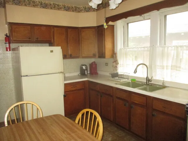 a kitchen with a sink a refrigerator and window
