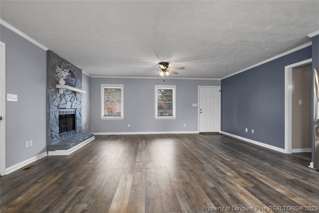 5843 Labonte Drive Hope Mills, NC 28348 - Photo 12 of 43 an empty room with wooden floor fireplace and windows