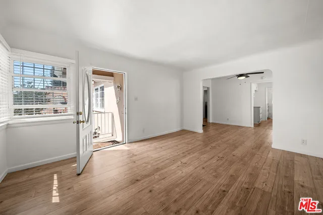 a view of a livingroom with wooden floor and a window