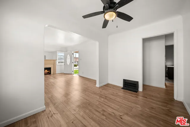 a view of an empty room with window and wooden floor