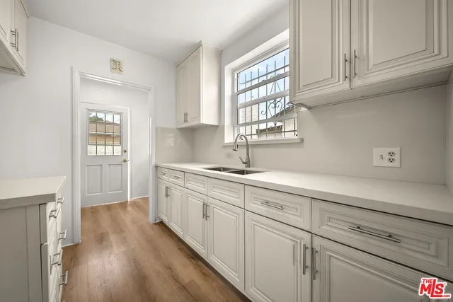 a kitchen with granite countertop white cabinets and a sink