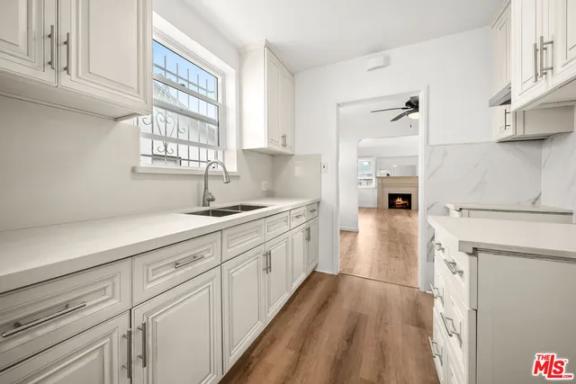 a kitchen with granite countertop white cabinets and white appliances
