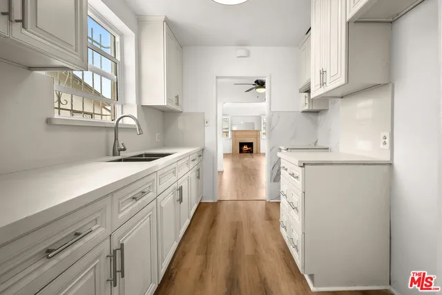 a kitchen with cabinets and wooden floor