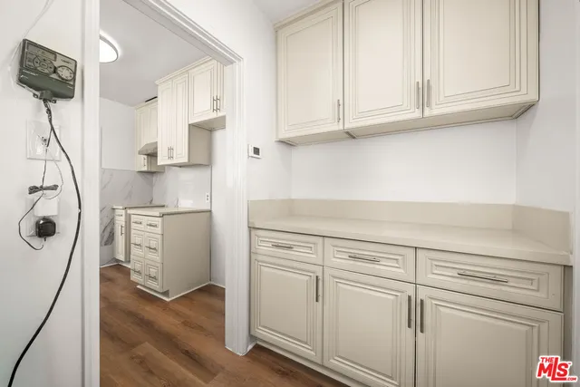 a kitchen with appliances cabinets and a wooden floor