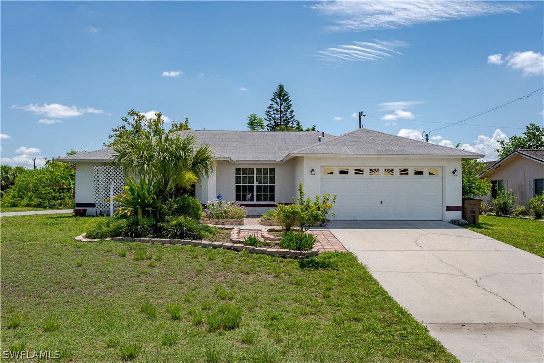 234 Connecticut Road Lehigh Acres, FL 33936 - Photo 1 of 19 a front view of a house with a yard and garage