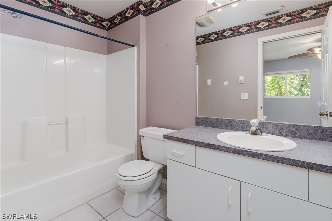 234 Connecticut Road Lehigh Acres, FL 33936 - Photo 11 of 19 a bathroom with a granite countertop sink mirror vanity and toilet