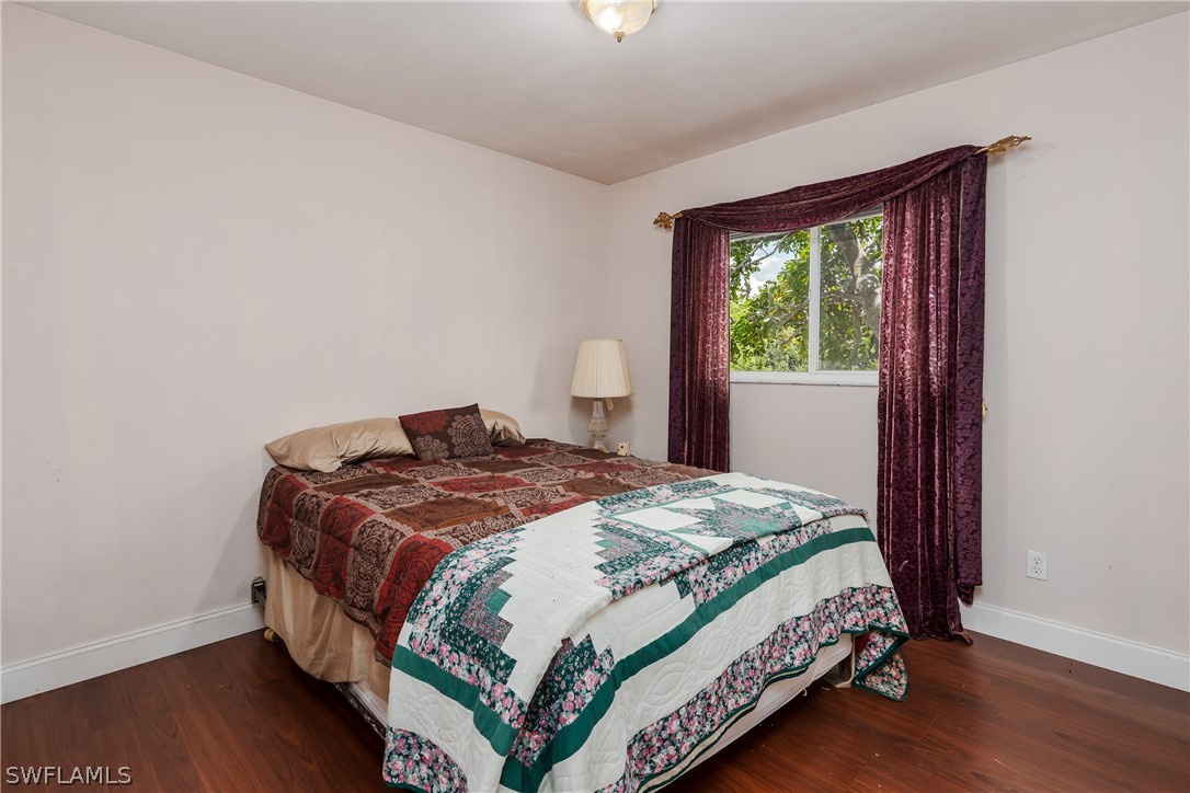 234 Connecticut Road Lehigh Acres, FL 33936 - Photo 13 of 19 a bedroom with a bed lamp and a window